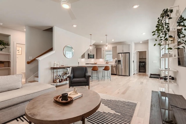 living room with light wood-type flooring and ceiling fan