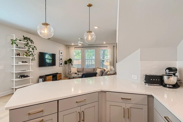 kitchen with pendant lighting, gray cabinetry, and kitchen peninsula