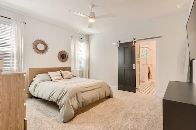 bedroom featuring ceiling fan, a barn door, and carpet floors