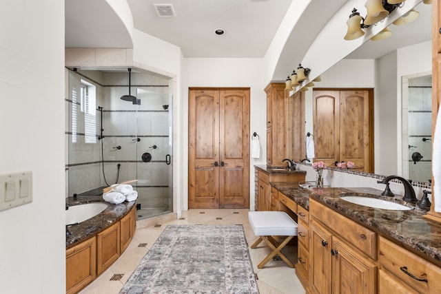 bathroom with vanity, tile patterned flooring, and plus walk in shower