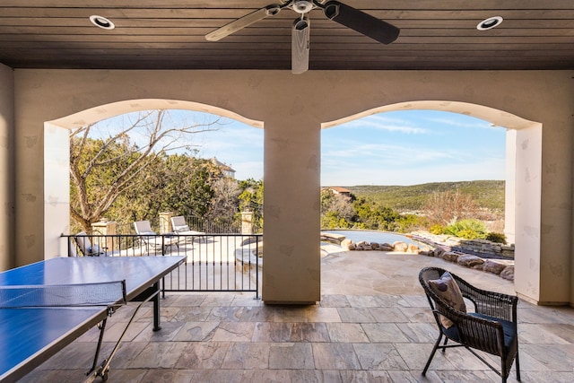 view of patio / terrace with ceiling fan and a mountain view