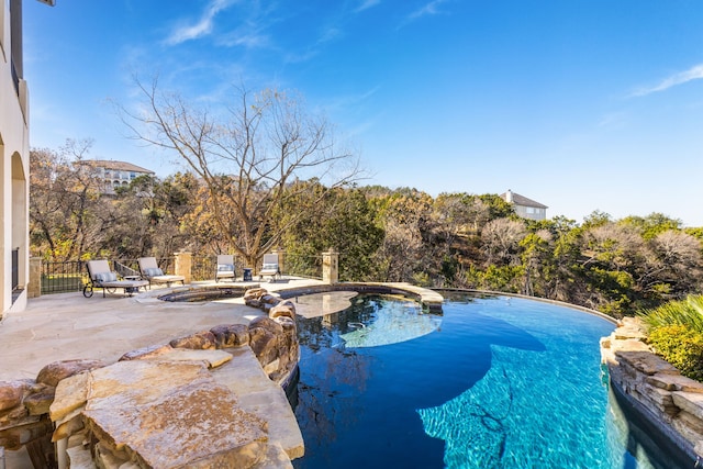 view of swimming pool with an in ground hot tub and a patio area