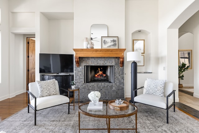 living room with a tile fireplace and hardwood / wood-style floors