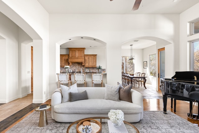 living room featuring ceiling fan with notable chandelier