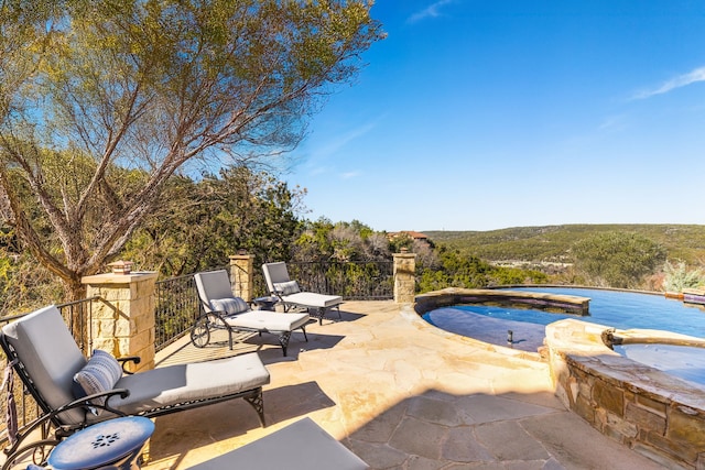 view of patio with a pool with hot tub