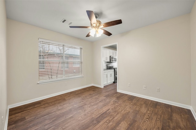 empty room featuring ceiling fan and dark hardwood / wood-style flooring