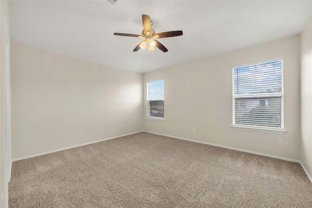 unfurnished room with ceiling fan and carpet