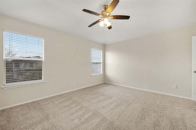 carpeted spare room featuring ceiling fan