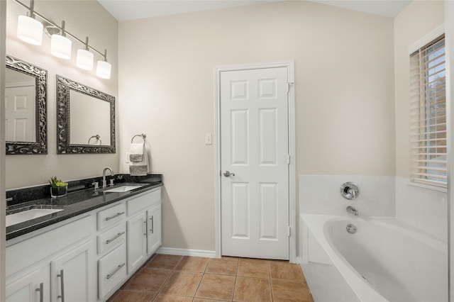 bathroom featuring vanity, tile patterned flooring, and a washtub