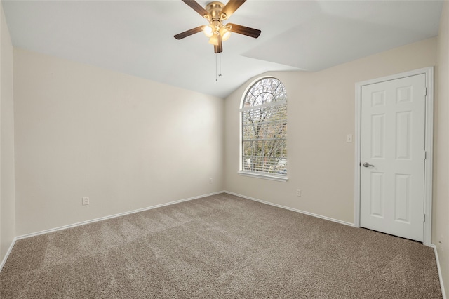 empty room featuring carpet, ceiling fan, and vaulted ceiling