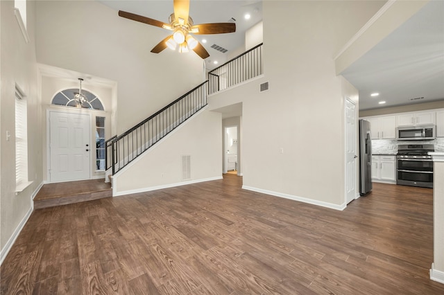 unfurnished living room with a high ceiling, hardwood / wood-style flooring, and ceiling fan