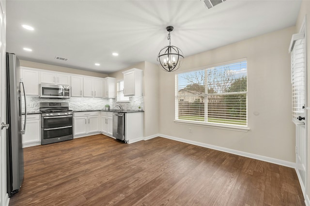 kitchen featuring white cabinetry, pendant lighting, a notable chandelier, and appliances with stainless steel finishes