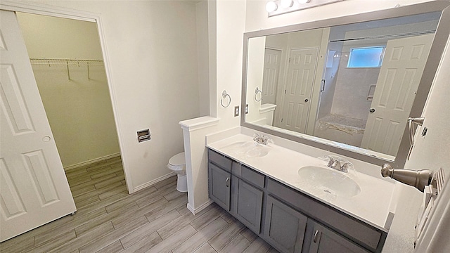 bathroom with an enclosed shower, vanity, and toilet