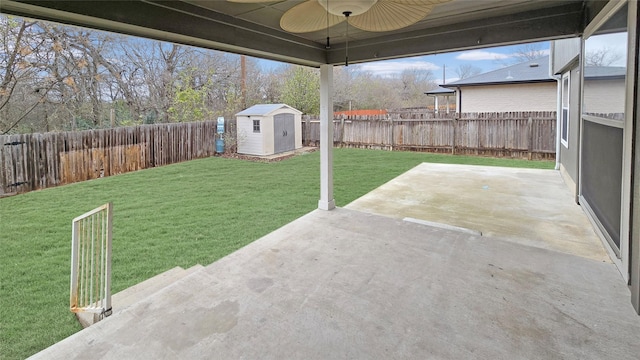 view of yard with ceiling fan, a shed, and a patio area