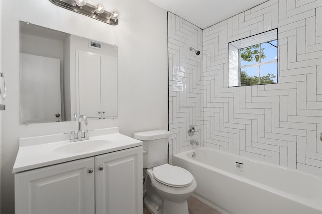 full bathroom featuring vanity, tiled shower / bath combo, and toilet