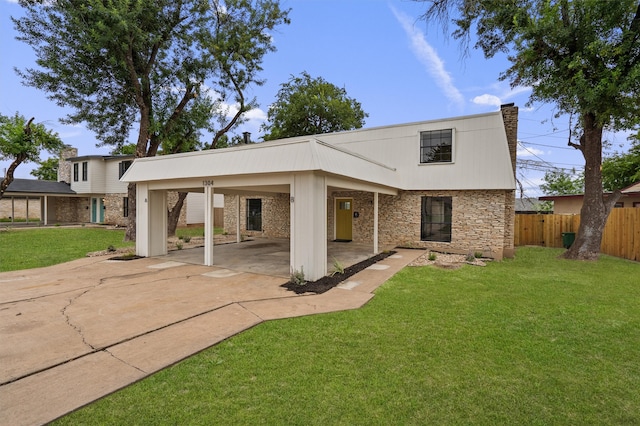 rear view of house with a yard and a carport