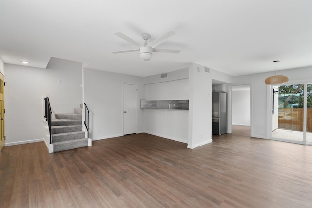 unfurnished living room featuring ceiling fan, dark hardwood / wood-style flooring, and sink