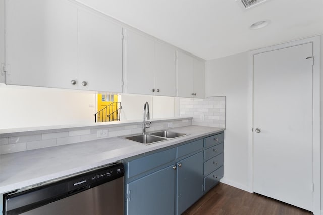 kitchen with sink, blue cabinets, white cabinets, stainless steel dishwasher, and dark hardwood / wood-style floors