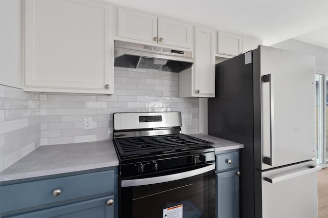 kitchen featuring fridge, white cabinets, blue cabinetry, and stainless steel gas range oven