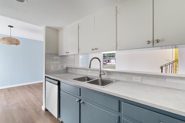 kitchen with sink, decorative light fixtures, white cabinetry, dishwasher, and tasteful backsplash