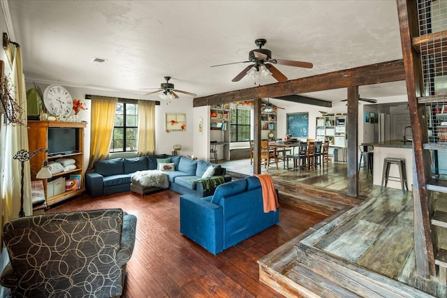 living room with sink, beamed ceiling, ornamental molding, ceiling fan, and dark hardwood / wood-style floors