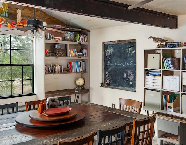 dining space with ceiling fan and beamed ceiling