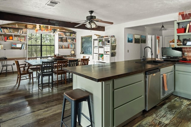 kitchen with a textured ceiling, green cabinetry, dark hardwood / wood-style flooring, and sink