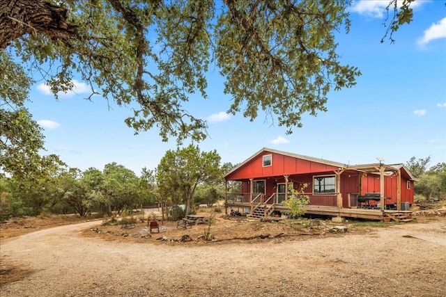 exterior space featuring dirt driveway, a porch, and board and batten siding