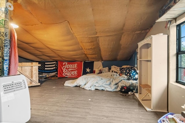 unfurnished bedroom with dark wood-style floors and lofted ceiling