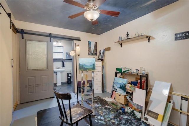 interior space featuring a barn door, concrete floors, and a ceiling fan