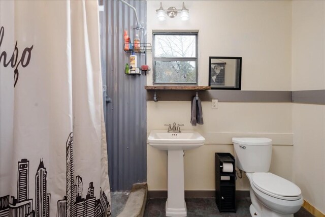 full bathroom with toilet, baseboards, and a sink