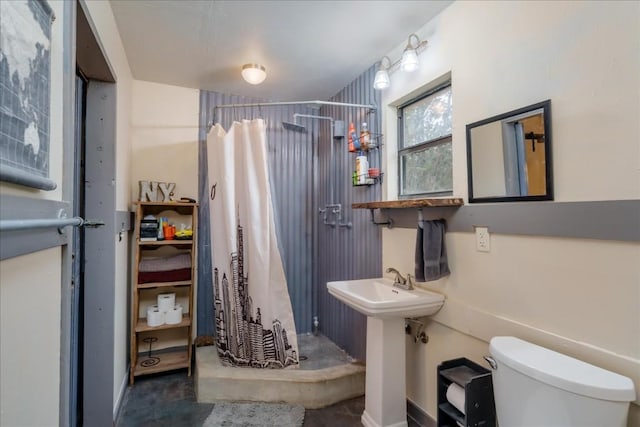 full bathroom featuring a stall shower, a sink, and toilet