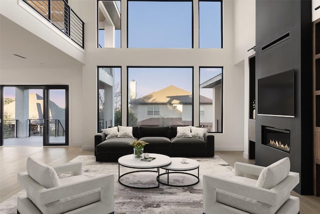 living room with a high ceiling and light hardwood / wood-style flooring