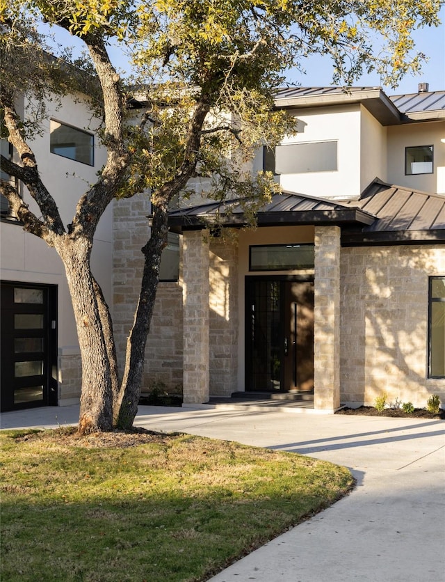 doorway to property with a lawn