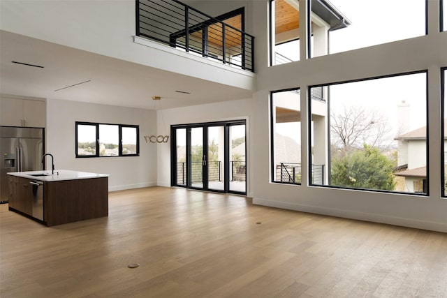 unfurnished living room featuring light wood-type flooring and sink