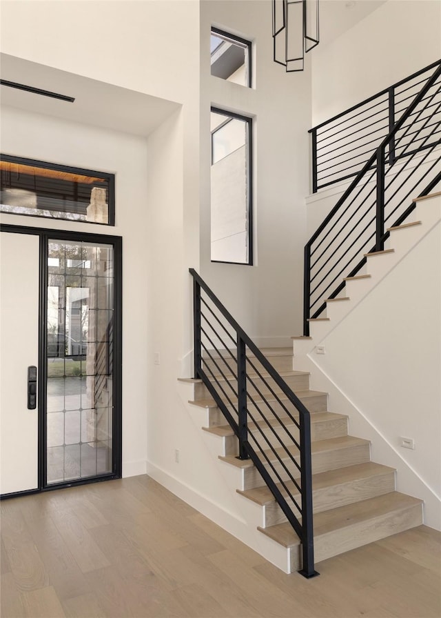 foyer featuring a towering ceiling and light hardwood / wood-style flooring