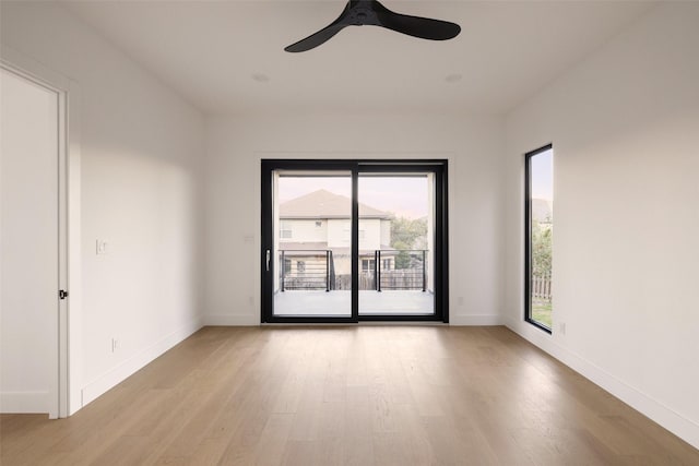 empty room featuring ceiling fan, a wealth of natural light, and light hardwood / wood-style flooring