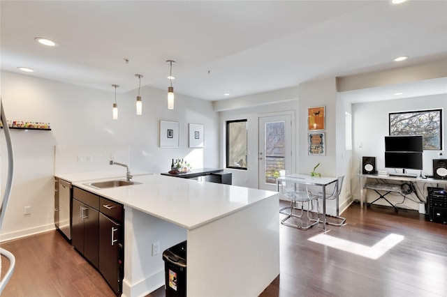 kitchen featuring kitchen peninsula, dishwasher, hanging light fixtures, dark brown cabinets, and sink