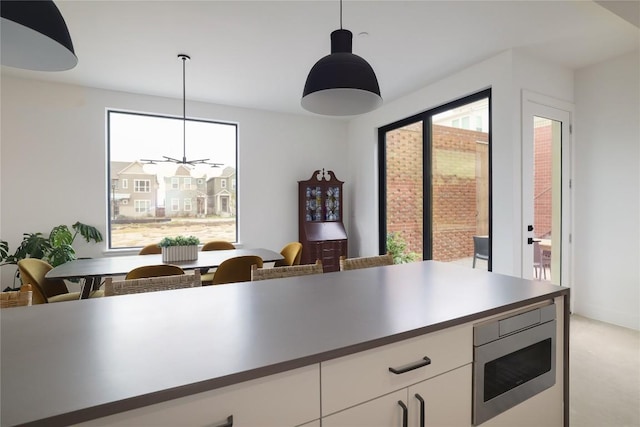 3008 Sorin St, Austin, TX 78723 - kitchen featuring stainless steel microwave, plenty of natural light, and hanging light fixtures