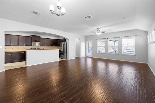 unfurnished living room featuring ceiling fan with notable chandelier and light hardwood / wood-style flooring