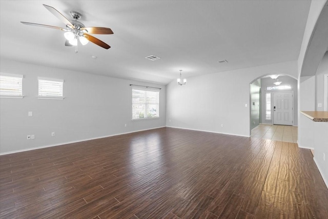 unfurnished living room featuring ceiling fan with notable chandelier and dark hardwood / wood-style floors