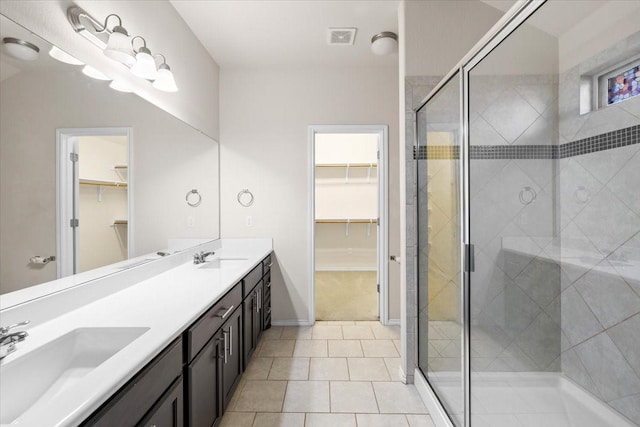 bathroom with tile patterned flooring, a shower with door, and vanity