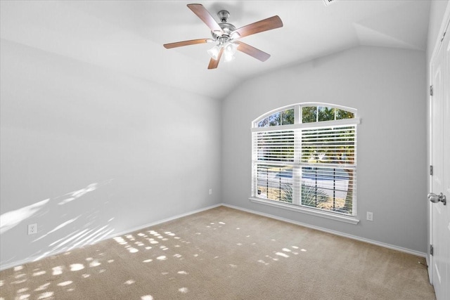 carpeted spare room with ceiling fan and vaulted ceiling