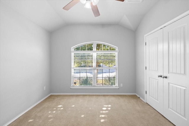 empty room featuring ceiling fan, light carpet, and lofted ceiling