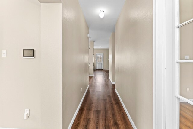 hallway with dark hardwood / wood-style flooring