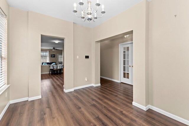 interior space featuring ceiling fan with notable chandelier and dark wood-type flooring