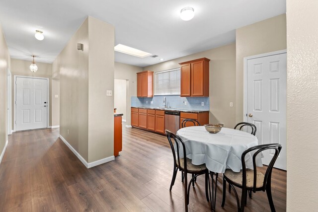 dining space with sink, dark hardwood / wood-style flooring, and a skylight