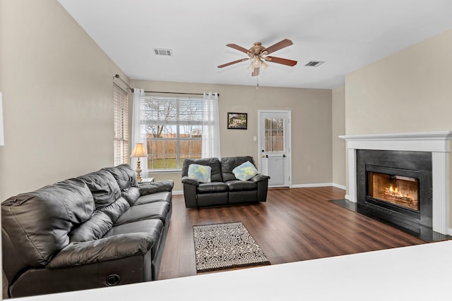 living room with ceiling fan and dark wood-type flooring