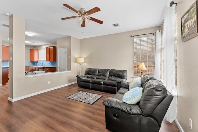 living room featuring sink, wood-type flooring, and ceiling fan