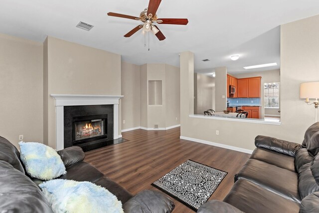 living room with ceiling fan and dark hardwood / wood-style floors